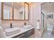 Modern bathroom featuring double sinks, a black-and-white tiled floor, and a shower at 110 Duckwood Ln, Cary, NC 27518