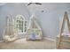 Bedroom view with hanging chair, white crib with baby dress, and a sunny window at 110 Duckwood Ln, Cary, NC 27518