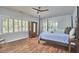 Bedroom with neutral walls, hardwood floors, shuttered windows, and an antique wood armoire at 110 Duckwood Ln, Cary, NC 27518