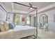 Spacious bedroom with tray ceiling, four-poster bed, and sitting area with chairs at 110 Duckwood Ln, Cary, NC 27518