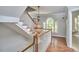 Bright hallway featuring wood floors, a large window, and a decorative chandelier at 110 Duckwood Ln, Cary, NC 27518