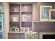 Detailed view of a living room's built-in shelving and fireplace with decorative artwork at 110 Duckwood Ln, Cary, NC 27518