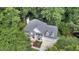 Aerial view of a two-story home with mature trees surrounding a landscaped yard, a spacious driveway, and gray roof at 12 Gatesway Ct, Durham, NC 27707