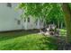 Landscaped backyard featuring a fire pit, stone patio, and mature trees provides a relaxing outdoor space at 12 Gatesway Ct, Durham, NC 27707