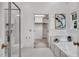 Bright bathroom featuring a bathtub, glass shower, and a separate entrance to the walk-in closet at 12 Gatesway Ct, Durham, NC 27707
