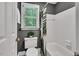 Bathroom with gray paint, white shower-tub, and window overlooking the lush greenery outside at 12 Gatesway Ct, Durham, NC 27707