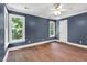 Spacious bedroom with blue walls, hardwood floors, crown molding, a fan, and natural lighting at 12 Gatesway Ct, Durham, NC 27707