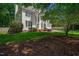 Two-story home featuring a manicured lawn, mature trees, and a partial view of the driveway at 12 Gatesway Ct, Durham, NC 27707