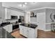 Modern kitchen boasts stainless steel appliances, granite countertops, white cabinetry, and hardwood flooring at 12 Gatesway Ct, Durham, NC 27707