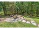 Backyard area featuring stone firepit seating area and stone walkway leading to the home at 126 Captains Ct, Durham, NC 27712