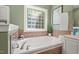 Bright bathroom with a soaking tub beneath a window, featuring tile and modern fixtures at 126 Captains Ct, Durham, NC 27712