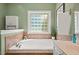 Bright bathroom with a soaking tub beneath a window, featuring tile and modern fixtures at 126 Captains Ct, Durham, NC 27712