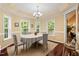 Elegant dining room with hardwood floors, chandelier, and large windows overlooking the backyard at 126 Captains Ct, Durham, NC 27712