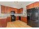 View of a well-lit kitchen with wood cabinets and black appliances at 127 Strike Eagle Dr, Broadway, NC 27505