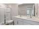 Bright bathroom featuring a glass-enclosed shower and double sink vanity with a large mirror at 134 Rusling Leaf Dr, Fuquay Varina, NC 27526