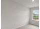 Bright, empty bedroom featuring a window view of lush green landscape and carpeted floor at 134 Rusling Leaf Dr, Fuquay Varina, NC 27526