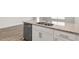 Close-up of a kitchen island featuring granite countertops, stainless steel sink, and modern cabinetry at 134 Rusling Leaf Dr, Fuquay Varina, NC 27526