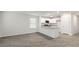 Open-concept living space featuring wood-look floors, white walls, and a kitchen view at 134 Rusling Leaf Dr, Fuquay Varina, NC 27526