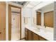 Bright bathroom features a skylight, neutral wallpaper, a white sink, and wood cabinets at 14 Quintin Pl, Durham, NC 27705