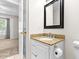 Bathroom featuring granite countertop, a white cabinet, and a framed mirror at 144 Greenmont Ln, Cary, NC 27511