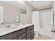 A bathroom featuring double sinks, a large mirror, and a shower with a curtain at 1471 Carlton Links Dr, Fuquay Varina, NC 27526