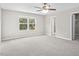 Large bedroom featuring neutral carpet, a ceiling fan, and a window with a view to trees at 1471 Carlton Links Dr, Fuquay Varina, NC 27526