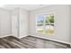 Light-filled bedroom featuring modern flooring and a view to the landscaped front yard at 1471 Carlton Links Dr, Fuquay Varina, NC 27526