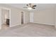 Spacious bedroom featuring a ceiling fan, neutral carpet, and access to bathroom and walk-in closet at 1471 Carlton Links Dr, Fuquay Varina, NC 27526