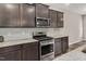 Modern kitchen featuring stainless steel appliances, dark cabinetry, and granite countertops at 1471 Carlton Links Dr, Fuquay Varina, NC 27526