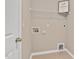 Bright laundry room with tile floors, utility connections, and wire shelving storage at 1471 Carlton Links Dr, Fuquay Varina, NC 27526