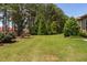 Beautiful backyard with manicured lawn, trees, and landscaping at 1523 Anthology Dr, Durham, NC 27703