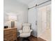 Bedroom showing an executive chair next to a sliding barn door and a glimpse of an en suite bathroom at 1523 Anthology Dr, Durham, NC 27703