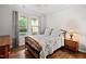 Cozy bedroom featuring a wooden bed frame, hardwood floors and natural light from large double windows at 1523 Anthology Dr, Durham, NC 27703
