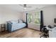 Bright bedroom with hardwood flooring, a daybed, and a large window, creating a cozy and inviting space at 1523 Anthology Dr, Durham, NC 27703