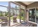 Enclosed sunroom with tile flooring, ample seating, and views of the landscaped backyard at 1523 Anthology Dr, Durham, NC 27703