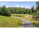 Community walking path near a pond lined with mature trees and landscaping at 1523 Anthology Dr, Durham, NC 27703