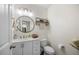 Half-bath featuring a white vanity, a decorative mirror, and modern fixtures with stylish wall décor at 175 Hawkesburg Dr, Clayton, NC 27527