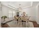 Elegant dining room featuring a decorative chandelier, a wooden table with seating for six, and wainscoting details at 175 Hawkesburg Dr, Clayton, NC 27527