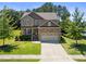 Charming two-story home featuring a stone-accented facade, well-maintained landscaping, and a two-car garage at 175 Hawkesburg Dr, Clayton, NC 27527