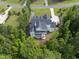 An aerial view of a beautiful gray home with a screened-in back porch surrounded by mature trees at 175 Stonecrest Way, Pittsboro, NC 27312