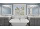 Bright bathroom featuring a soaking tub, dual vanities with marble countertops, and stylish fixtures at 175 Stonecrest Way, Pittsboro, NC 27312