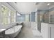 Bathroom featuring soaking tub, dual vanities, marble countertops, and separate glass-enclosed shower at 175 Stonecrest Way, Pittsboro, NC 27312