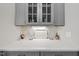Close-up of butler's pantry with gray cabinets, quartz countertop, and marble backsplash at 175 Stonecrest Way, Pittsboro, NC 27312