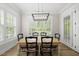 Light-filled dining room with wood floors, large windows with plantation shutters, and a modern pendant light at 175 Stonecrest Way, Pittsboro, NC 27312