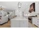 Open-concept kitchen island with quartz countertop, stainless steel appliances, and adjacent living area at 175 Stonecrest Way, Pittsboro, NC 27312
