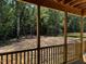 Relax on this back porch with natural wood columns and railings offering views of the wooded backyard at 178 Seahawk Way, Zebulon, NC 27597