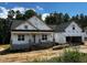 New two-story home features a covered porch and an attached garage with unfinished exterior at 178 Seahawk Way, Zebulon, NC 27597