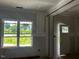 Bright living room features a large window overlooking the front yard and an open door at 178 Seahawk Way, Zebulon, NC 27597
