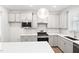 Modern kitchen with gray cabinets, stainless steel appliances, herringbone backsplash and a sleek white countertop at 1812 Gazania Dr, Fuquay Varina, NC 27526