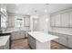 Light-filled kitchen showcasing gray cabinets, an island with seating, and stainless steel appliances at 1812 Gazania Dr, Fuquay Varina, NC 27526